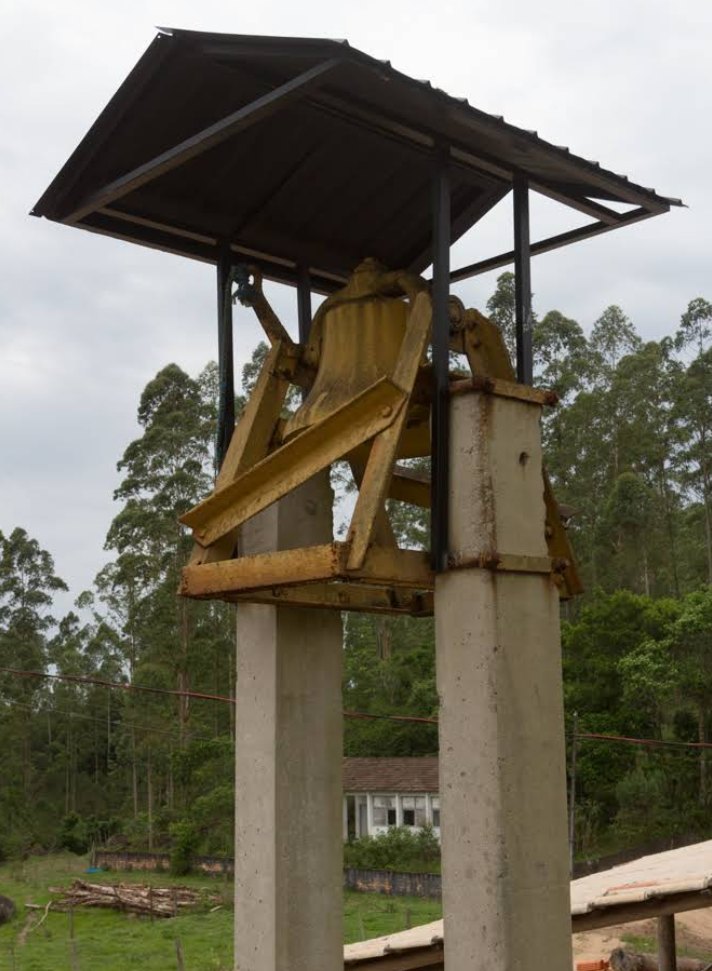 O sino de bronze sob pequena cobertura de telhas, sustentado por dois pilares de concreto.